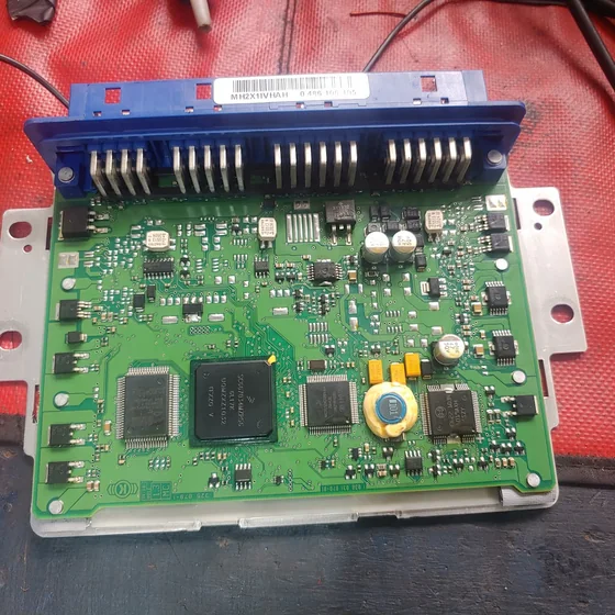 Computadora de motor abierta sobre la mesa de trabajo, con la placa electrónica a la vista